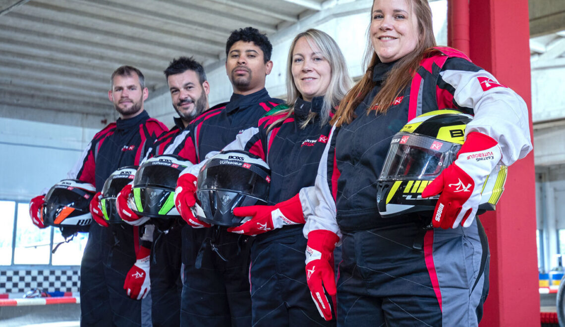 Groupe de 5 pilotes en combinaison alignés avec casque à la main, Karting de Vuiteboeuf