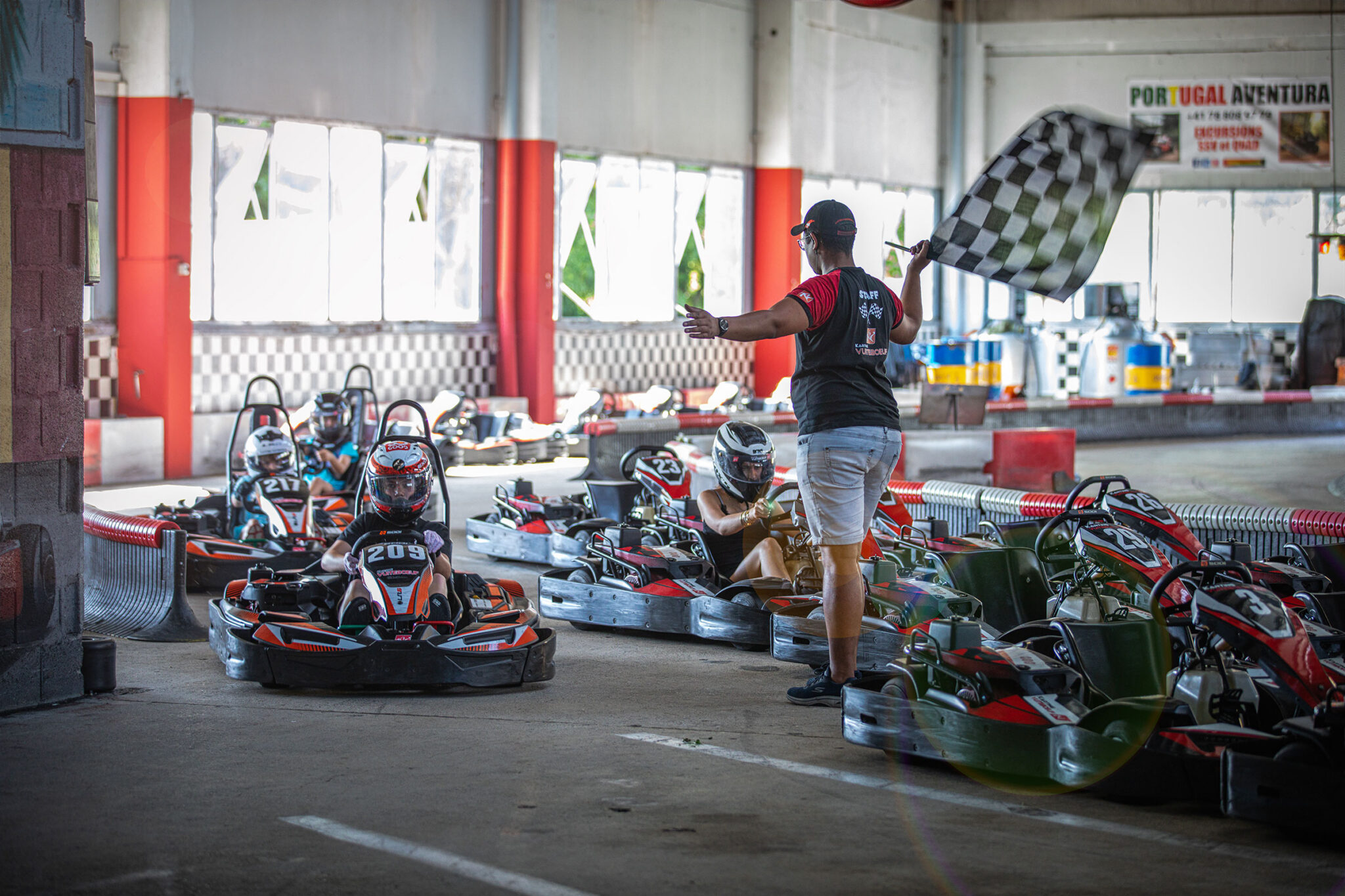 Arrivée de course des karts guidés par le commissaire de course et son drapeau à damier au Karting de Vuiteboeuf